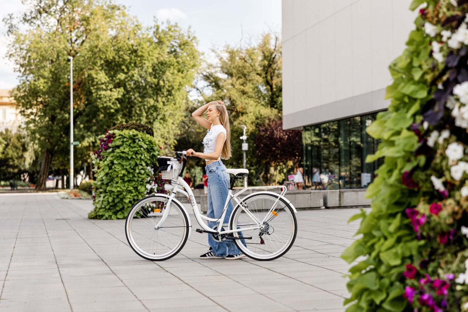 Kvinna med cykel i stadsmiljö.