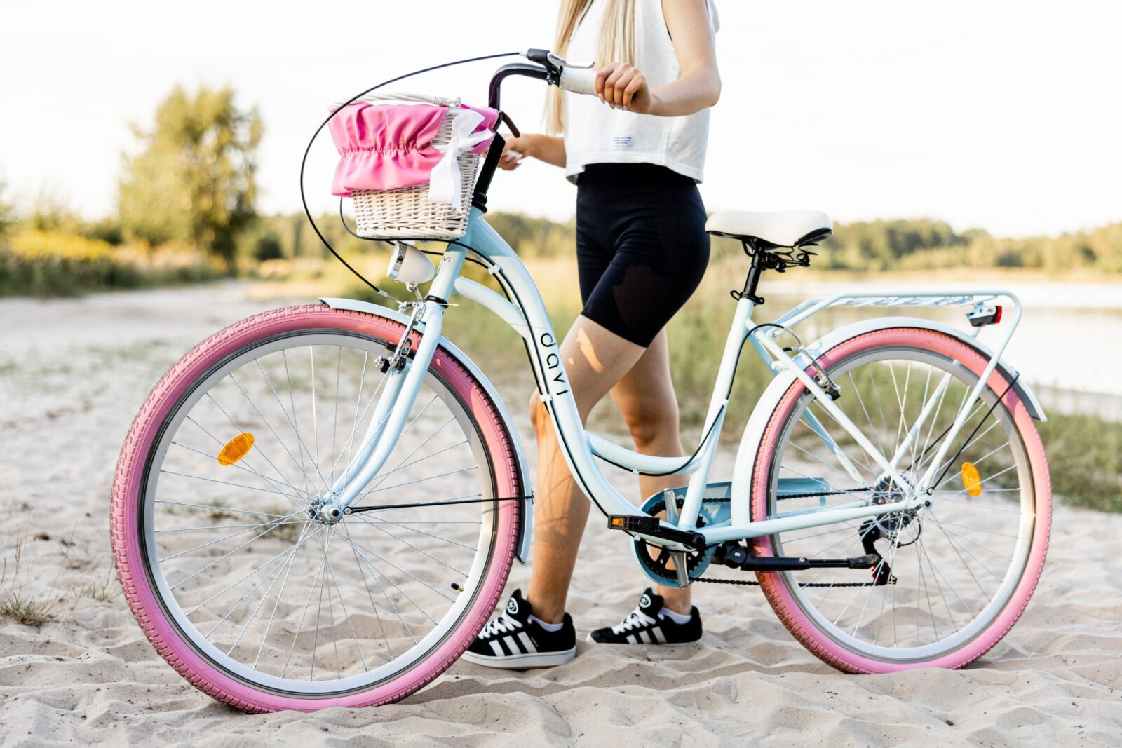 Kvinna med cykel på sandstrand