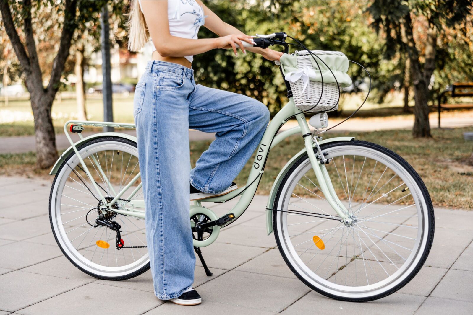 Person cyklar på grön cykel i parkmiljö.