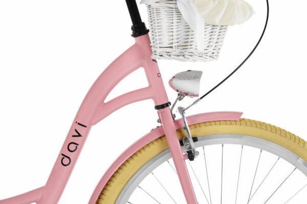 Rosa cykel med korg och gula däck.