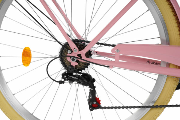 Närbild av rosa cykel med gula däck