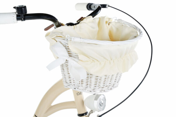Vit cykelkorg med krämfärgad tygprydnad fram på cykel.